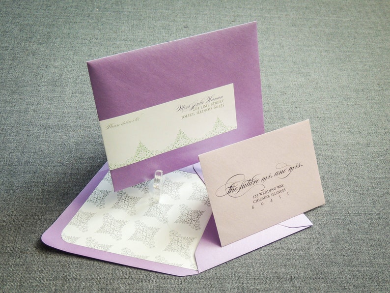 May include: Two purple envelopes with white and green floral designs. The top envelope has the text "The future is, and yours." and the address "111 Wedding Way, Chicago, Illinois 60411". The bottom envelope has the text "Please address to" and the address "111 Live Street, Joliet, Illinois 60431".