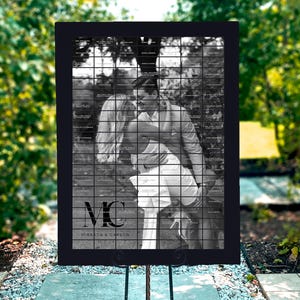 Könnte beinhalten: Schwarz-weißes Hochzeitssitzplan mit einem Foto eines sich küssenden Paares. Der Plan ist schwarz gerahmt und trägt die Initialen des Paares "MC" sowie die Namen "Miranda & Carson" unter dem Foto.