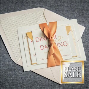 May include: A set of wedding invitations with a peach-colored ribbon and gold accents. The invitation reads "Dinner and Dancing". The text "Flash Sale" is visible in the lower right corner.