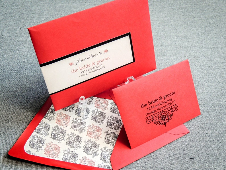 Może przedstawiać: Dwie czerwone koperty z czarnym tekstem. G&oacute;rna koperta ma białą etykietę z tekstem "please deliver to the bride & groom 1934 wedding way chicago, illinois 60610". Dolna koperta ma czarny tekst z ozdobną ramką i tekstem "the bride & groom 1234 wedding way chicago, illinois 60610".