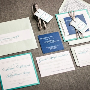 May include: Wedding invitation suite with teal and navy blue accents. The invitation features the names "Sarah Stevens" and "Matthew Gray" in elegant calligraphy. The RSVP card says "Reception".