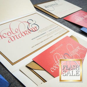 Puede incluir: Un conjunto de invitaciones de boda con un diseño dorado y blanco. La invitación presenta los nombres "nicole & andrew" en una fuente cursiva. La tarjeta RSVP tiene un borde dorado y el texto "Respond". La tarjeta de recepción es roja y presenta el texto "Por favor, únase a nosotros para cócteles y cena".