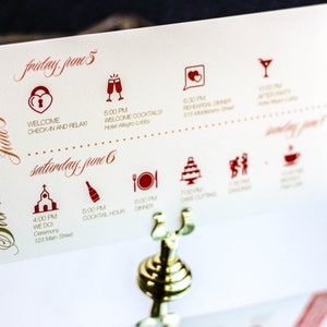 May include: A white wedding invitation card with red and gold lettering. The card lists the wedding weekend schedule, including a welcome cocktail hour, ceremony, and dinner. The text reads "Welcome! Sarah & Joshua June 5 - 6 Friday June 5 Welcome Check-in and Relax 6:00 PM Welcome Cocktails Hotel Allegro Lobby 6:30 PM Rehearsal Dinner 6:30 PM Saturday June 6 4:00 PM We Do Ceremony 123 Main Street 6:00 PM Cocktail Hour 6:00 PM Dinner"