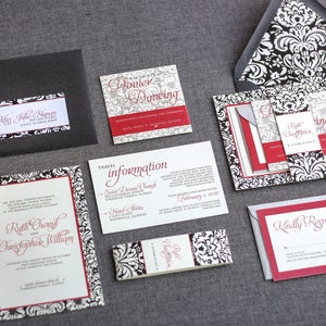 May include: Black and white damask patterned wedding invitation suite with red accents. The invitation includes the names Ruth Cronyn and Christopher William, the date February 1, 2014, and the location Saint Dennis Church. The RSVP card says "Kindly Respond".