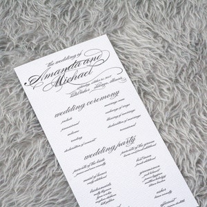 May include: A wedding ceremony programme with the names Amanda and Michael in elegant script. The programme lists the order of events for the wedding ceremony and reception.