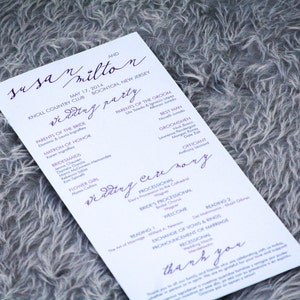 May include: A wedding ceremony programme with purple text on white paper. The programme lists the wedding party, the processional, and the ceremony details. The text includes the names "Susa Milton", "May 17, 2014", "Knoll Country Club", and "Boonton, New Jersey".
