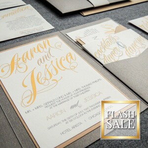 May include: A gray and beige wedding invitation with gold calligraphy. The invitation reads "Aaron and Jessica" and includes details about the wedding ceremony and reception. The invitation is folded in half and has a pocket on the inside for a RSVP card.
