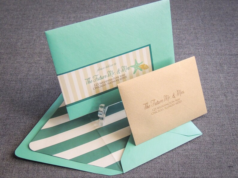 May include: A light blue envelope with a white and yellow striped design and the text "The Future Mr. & Mrs. 123 Weddington Way Chicago, Illinois 60601" is inside a larger light blue envelope with a white and green striped design. A smaller brown envelope with the text "The Future Mr. & Mrs. 123 Weddington Way Chicago, Illinois 60601" is inside the larger envelope.