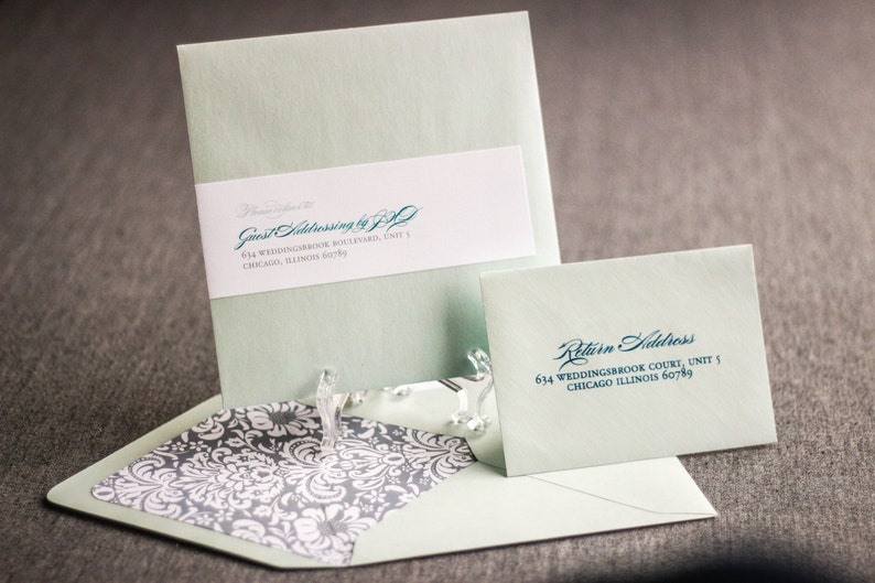 May include: A light green envelope with a white label that says "Guest Addressing by J.P." and a return address label that says "634 Weddingbrook Court, Unit 5, Chicago Illinois 60789".