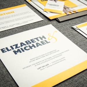May include: Wedding invitation with a yellow and white design. The invitation features the names "Elizabeth & Michael" in bold blue text. The text "Invite you to join in celebration as they begin their new life together" is printed in black text. The date and time of the wedding are listed as "Saturday, the ninth of October, two thousand twelve at five o'clock in the afternoon". The location is listed as "Loft on Lake | Chicago, Illinois".