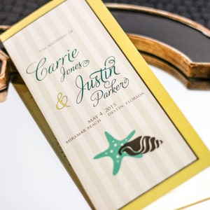 May include: A wedding program with a yellow border and a striped background. The text reads "The Wedding of Carrie Jones & Justin Parker" and "May 4, 2015 Miramar Beach, Destin, Florida". A green starfish and a brown seashell are illustrated on the bottom.