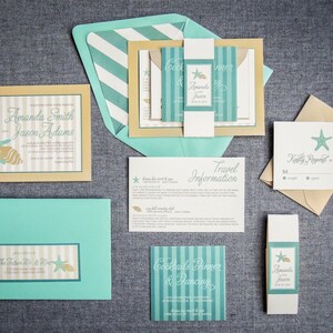 May include: A set of wedding invitations with a beach theme. The invitations are printed on beige cardstock with teal and white stripes. The invitations feature a seashell and starfish design. The text on the invitations reads "Amanda Smith & Jason Adams".