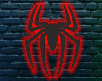 May include: A black spider emblem with a red glowing outline is mounted on a dark brick wall. The spider design has eight legs and a detailed body. The red glow creates a striking contrast against the dark background.