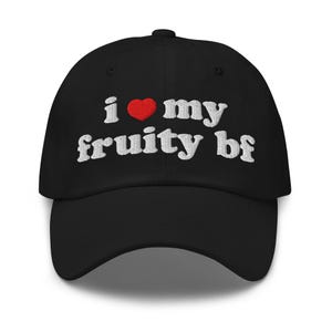 Pode incluir: Boné de beisebol preto com o texto bordado "i ❤️ my fruity bf" em branco, com um coração vermelho substituindo a palavra "love". O boné tem uma aba curva e um botão na parte superior.