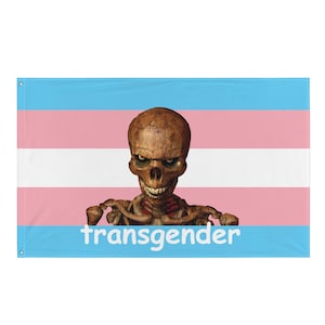 May include: A transgender pride flag with a skeletal figure in the center. The flag is blue, pink, and white with the word "transgender" printed in white at the bottom.