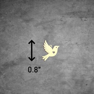 Puede incluir: Una peque&ntilde;a paloma de madera amarilla con un coraz&oacute;n recortado en el pecho. La paloma mide 0,8 pulgadas de alto.