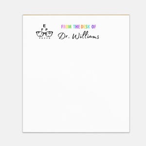 May include: White notepad with a rainbow colored eye chart and glasses graphic. The text "From the desk of Dr. Williams" is printed in rainbow colors.