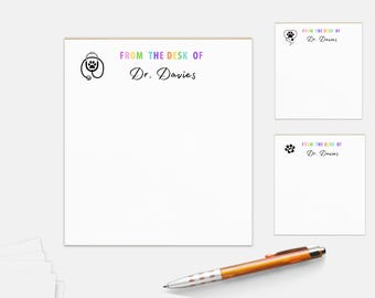 May include: A white notepad with the text "FROM THE DESK OF Dr. Davies" in rainbow colors. The notepad has a paw print with a stethoscope on it.