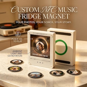 Könnte beinhalten: Ein weißer, rechteckiger NFC-Musik-Kühlschrankmagnet mit einem zentralen runden Display, das eine rotierende CD-Grafik und ein Paar-Foto zeigt. Das Gerät verfügt über Wiedergabesteuerungen, Umgebungslicht und fünf kleine, runde Fotomagnete.