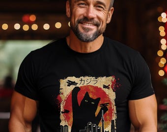 May include: Black t-shirt featuring a graphic of a cat silhouette in front of a red sun with Japanese text and the word "CATZILLA" below. The design includes stylized airplanes and a cityscape.