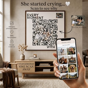 May include: A square wall art piece featuring a large black and white QR code with the text "EVERY MOMENT" above it. A smartphone in the foreground displays a digital photo album titled "MEMORIES ALBUM" with the text "Scan Successful!" at the top.