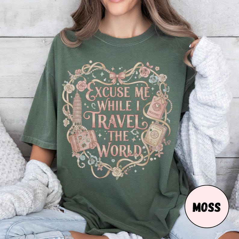 Vintage-inspired pink and beige travel-themed shirt with passport, suitcase, and the quote “Excuse Me While I Travel The World” framed in florals.
