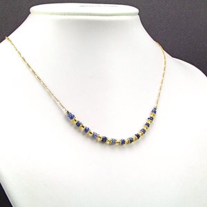 May include: A gold chain necklace with blue gemstone beads.