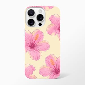 May include: A phone case with a repeating pattern of pink hibiscus flowers on a pale yellow background. The flowers have detailed petals and yellow stamens. The case has a camera module with three lenses.
