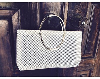 Bolso de mano de malla metálica blanca, estilo retro, con asa enmarcada en dorado, accesorio vintage