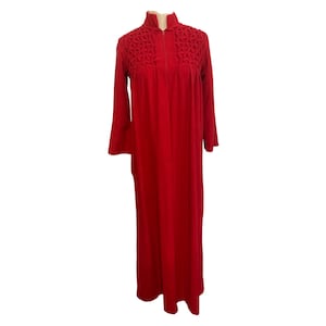 May include: A full-length, bright red robe with long sleeves and a high collar. The robe features a zipper closure and decorative textured detailing on the upper chest area. The robe is displayed on a mannequin against a white background.