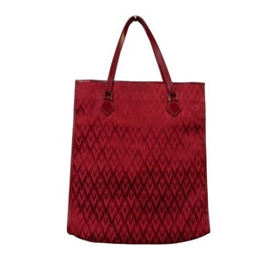 May include: A red tote bag with a repeating geometric pattern. The bag has two handles and a rectangular shape. The handles and trim are a darker shade of red. The bag is made of a textured material.