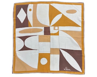 Può includere: Foulard quadrato in seta con un design geometrico astratto nei toni del marrone, bianco e oro. La sciarpa ha un bordo ed è firmata "Usna" in basso a destra. Forma quadrata.
