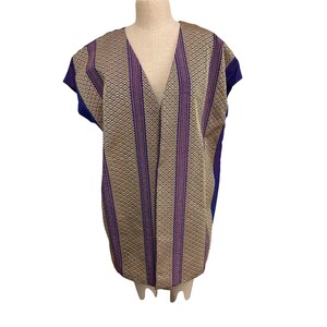 May include: A patterned, open-front garment with a V-neck. The fabric features a diamond and stripe design in gold, purple, and blue. The garment is displayed on a mannequin.