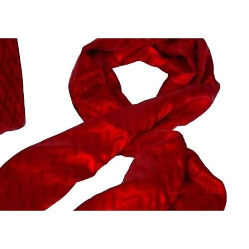 May include: A vibrant red scarf made of a soft, textured material. The scarf is draped and folded, showcasing its length and the rich color. The fabric has a subtle pattern, adding depth to the design.