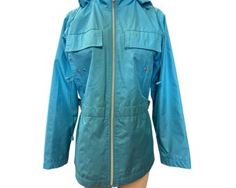 May include: A turquoise-blue jacket with a hood, two chest pockets, and a full-length zipper. The jacket has a cinched waist and long sleeves. The jacket is made of a lightweight material.