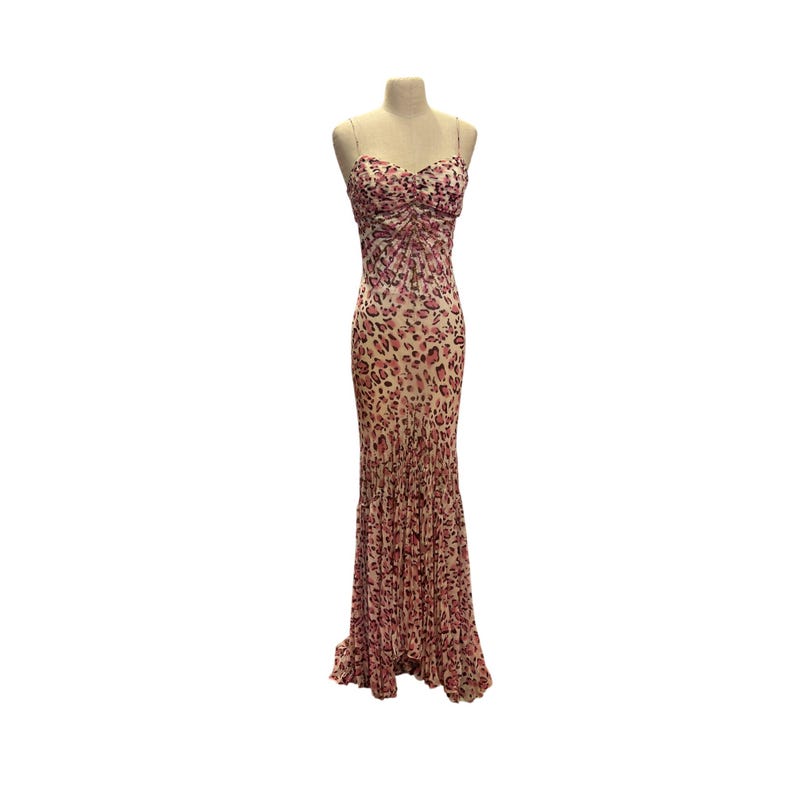 May include: A floor-length, strapless dress with a pink and beige leopard print. The bodice is ruched, and the skirt flares out at the bottom. The dress is displayed on a mannequin.