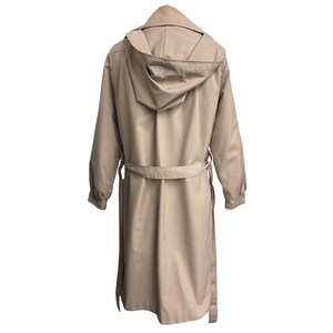 K&ouml;nnte beinhalten: Ein beigefarbener Trenchcoat mit Kapuze, langen &Auml;rmeln und einem G&uuml;rtel. Der Mantel ist aus einem glatten Stoff gefertigt und hat ein klassisches Design. Der Mantel ist neutralfarben und kann in verschiedenen Umgebungen getragen werden.