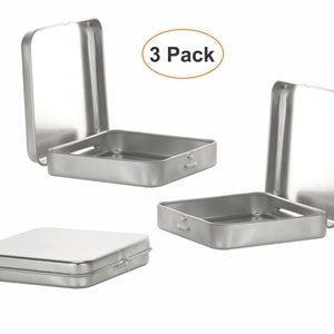 Può includere: Tre scatole di metallo argentate con coperchi a cerniera. Le scatole sono quadrate e hanno un design semplice. Il testo "3 Pack" è visibile nell'immagine.