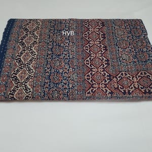 May include: A blue and red patterned cotton quilt with the text "HVB" in the centre.