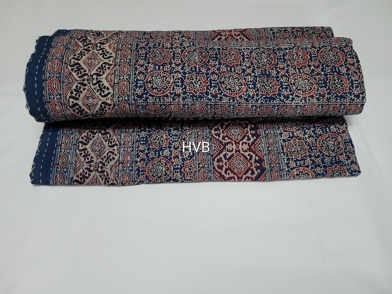 May include: A blue and white patterned fabric with a geometric design. The fabric is folded in half and has a tag that says "HVB" on it.