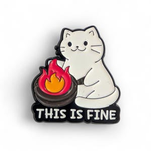 May include: A white cat cartoon with a black outline sits beside a campfire with red and yellow flames. The text "THIS IS FINE" is in white letters on a black background below the cat and fire.