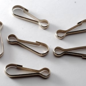 May include: Several silver-coloured metal spring snap hooks. These small, oval clasps feature a spring-loaded gate for secure fastening. Suitable for various crafting and DIY projects.