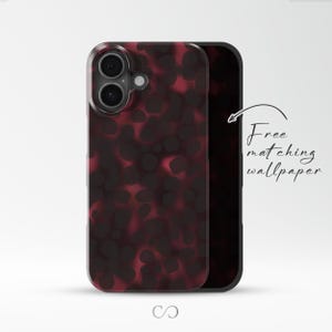 May include: A smartphone case with a tortoiseshell pattern in shades of burgundy and black. The case has a clear border and a black backing. The text "Free matching wallpaper" is written in cursive.