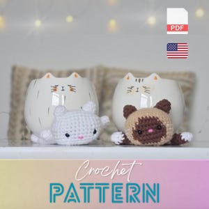 Peut inclure: Deux pots en céramique blancs en forme de chat avec des détails noirs et deux jouets pour chats crochetés. L'un est blanc, l'autre est marron et beige. L'image comprend le texte "Crochet PATTERN" et une icône PDF.