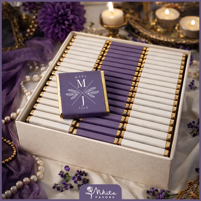 May include: A box of chocolates with a personalized wrapper. The chocolates are arranged in rows with alternating white and purple wrappers, accented with gold foil. The wrapper reads "MARY M J JACK".