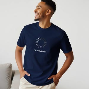 Op de afbeelding: Marineblauwe t-shirt met een wit laadsymbool en de tekst "I'M THINKING". Dit casual T-shirt is gemaakt van een zachte stof. Het ontwerp is een humoristische weergave van het denkproces.