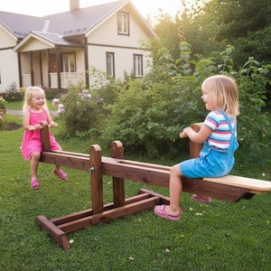 Könnte beinhalten: Zwei kleine Kinder spielen auf einer Holzwippe in einem Garten. Die Wippe ist aus dunkelbraunem Holz gefertigt. Die Kinder tragen Freizeitkleidung. Im Hintergrund ist ein Haus zu sehen. Die Wippe ist etwa 200 cm lang.