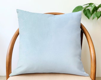 May include: A light blue throw pillow on a wooden chair. The pillow is plain and has no design.