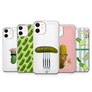 May include: Five clear phone cases featuring pickle designs. One shows a pickle with a pink beret and mustache, another a green pickle pattern, one a pickle on a fork, one a pickle with makeup, and one with green stripes and the text PICKLE BADDIE.