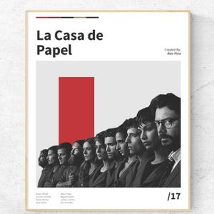 Puede incluir: Póster enmarcado con el texto "La Casa de Papel", un rectángulo rojo y una imagen en escala de grises de personas. El póster tiene un fondo blanco y un marco dorado.